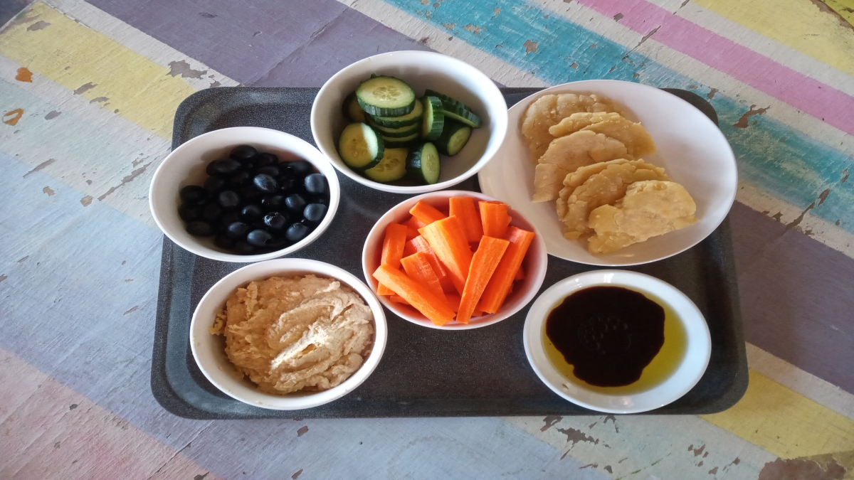 A simple starter of fresh vegetables, homemade gluten-free flat bread and houmous.